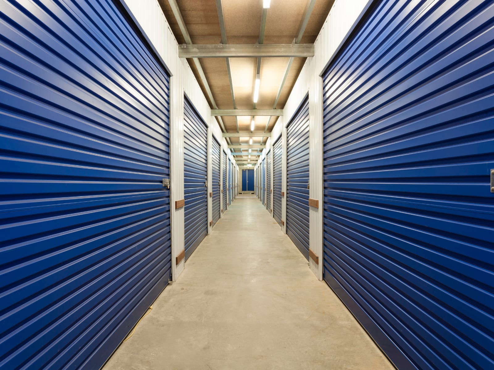 Corridor of secure self-storage units with roller shutter doors